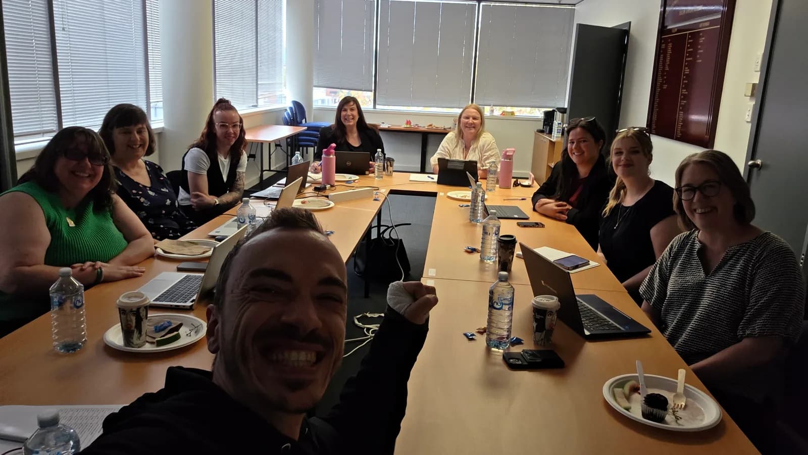 Attendees at a hands-on AI workshop in Adelaide working on their own open laptops around a boardroom table